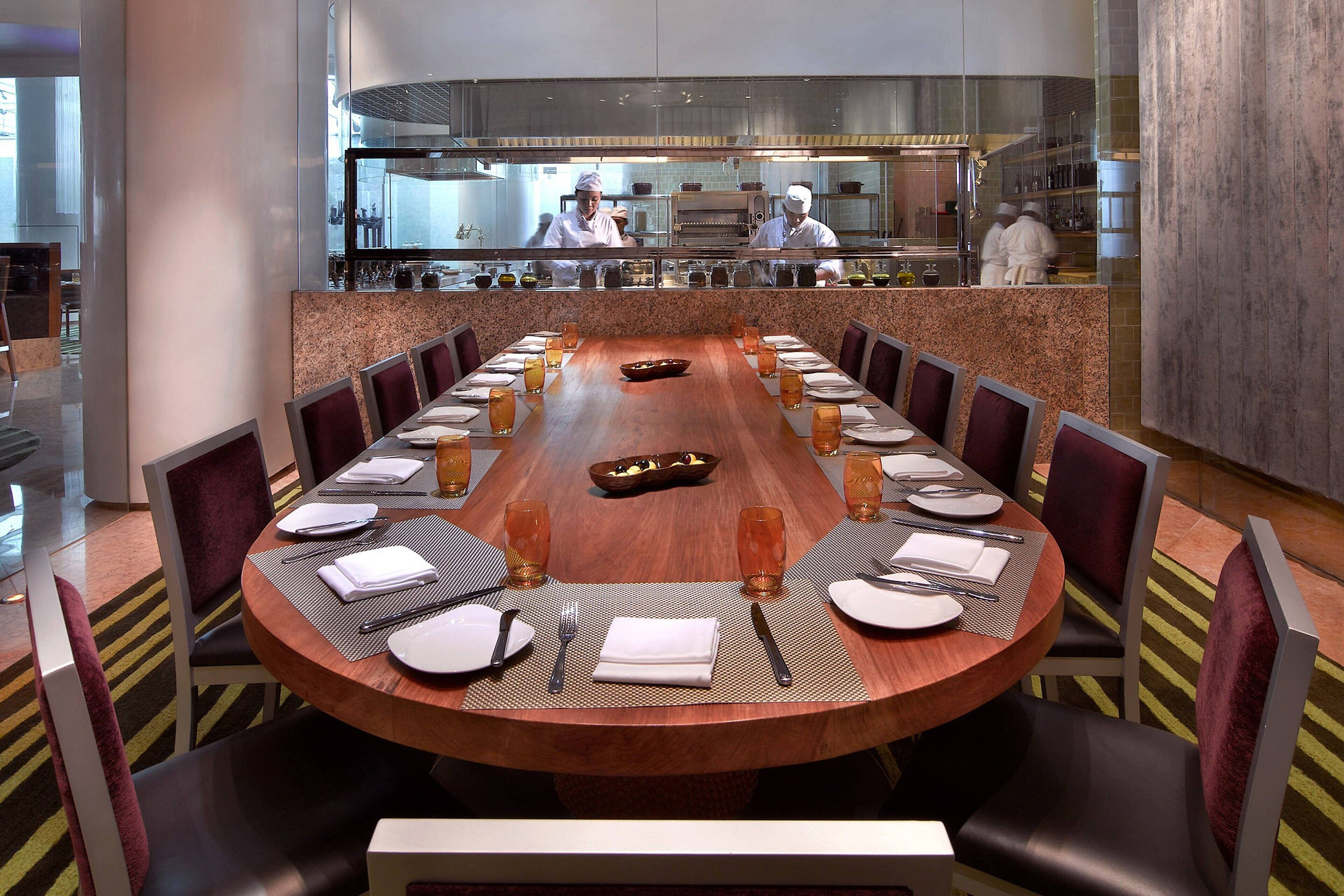 A conference room with a long table set for a meeting, surrounded by chairs.