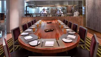 A conference room with a long table set for a meeting, surrounded by chairs.