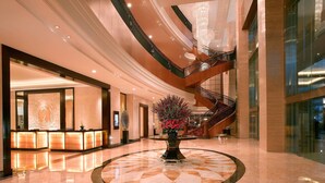 A spacious lobby with a central reception desk, a large chandelier, and a spiral staircase. - JW Marriott Hotel Medan (Medan)