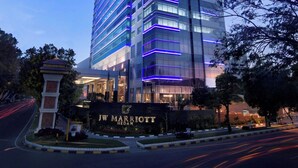 A tall, modern hotel with a prominent entrance and illuminated signage. - JW Marriott Hotel Medan (Medan)