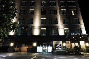 A multi-story hotel with a modern facade, illuminated windows, and a sign reading "BEAUTY HOTEL." - Taipei Roumei Boutique Hotel (Taipei)