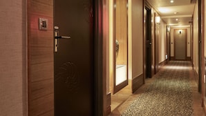 A hotel corridor with wooden walls, a patterned carpet, and a door with a keycard reader. - Taipei Roumei Boutique Hotel (Taipei)