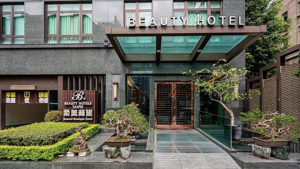 The exterior of the Beauty Hotel with a modern facade, a signboard for Beauty Hotels Taipei, and a well-maintained garden area with bonsai trees. - Taipei Roumei Boutique Hotel (Taipei)