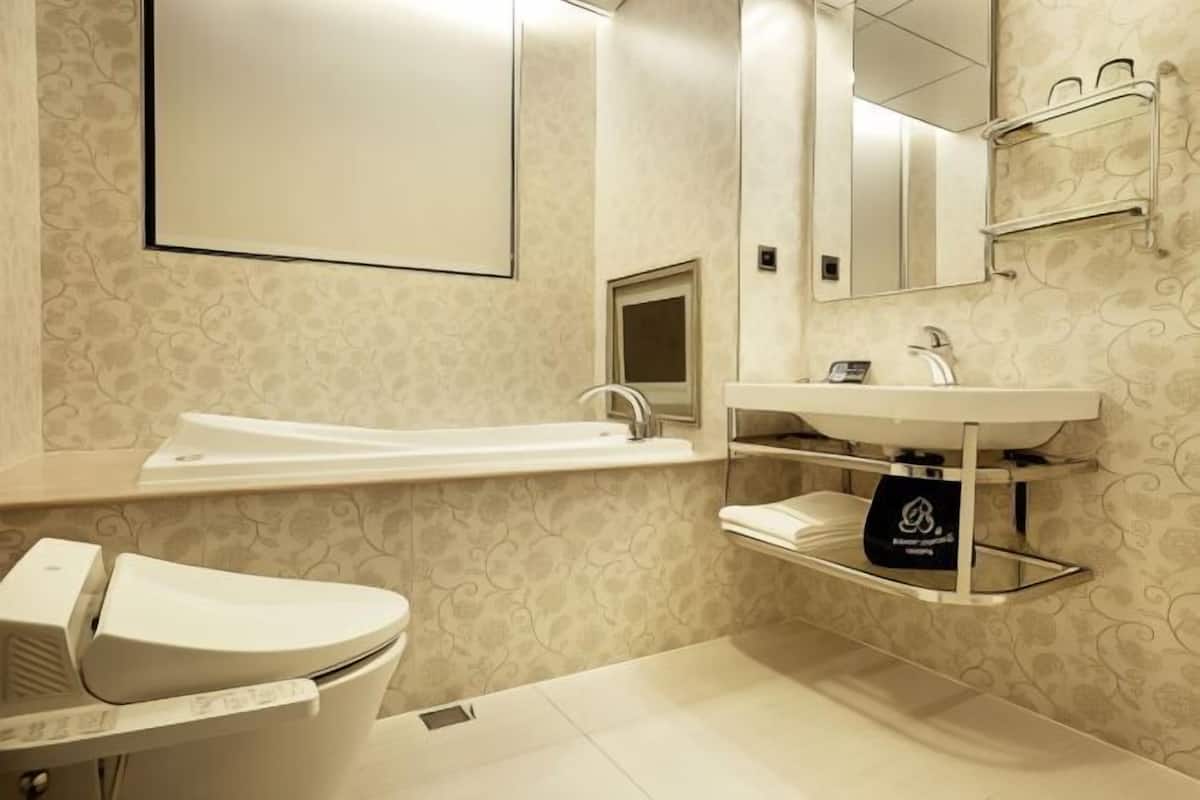 Badkamer | Een aparte badkuip en douche, een haardroger, pantoffels