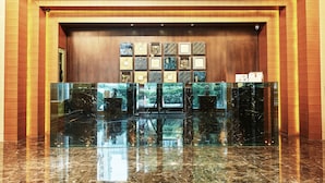 A lobby with a marble reception desk, framed artwork on the wall, and a wooden accent wall. - Taipei Roumei Boutique Hotel (Taipei)