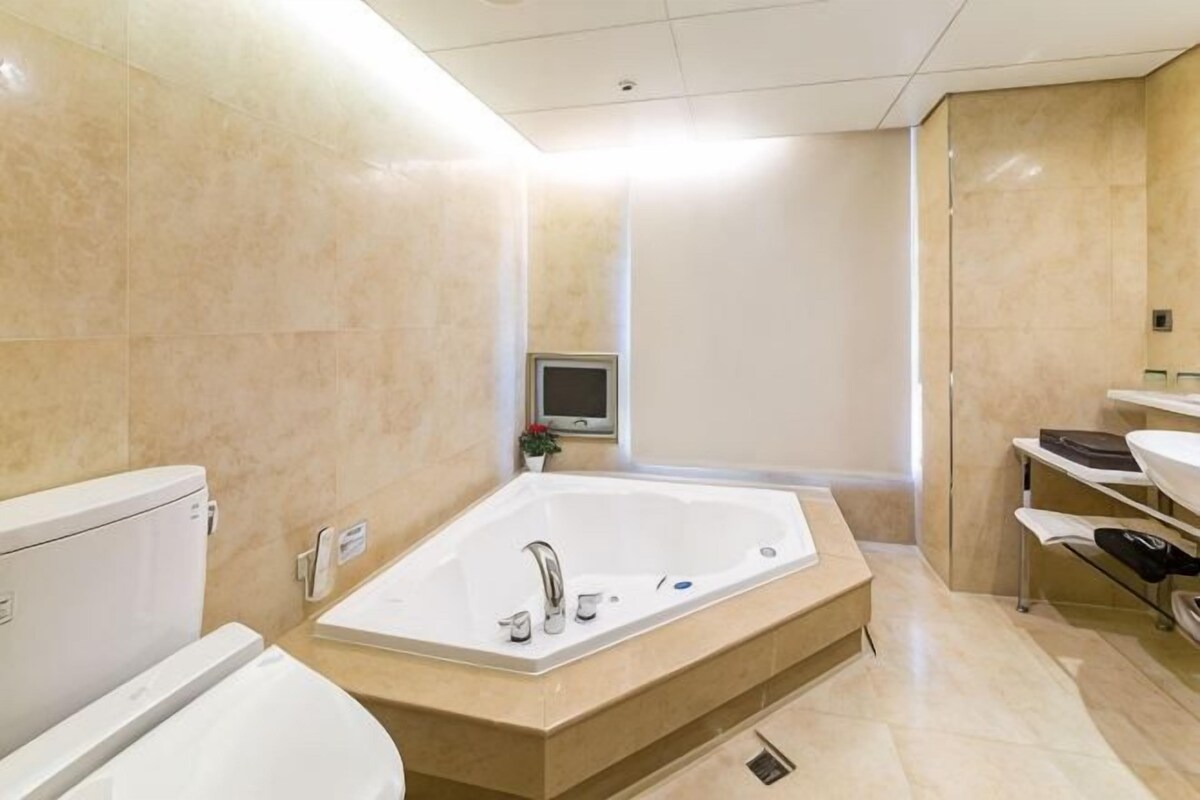 Une salle de bain moderne avec une grande baignoire, des toilettes et un lavabo.