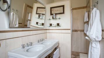 A bathroom with two sinks, a large mirror, and a towel rack.
