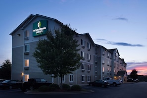 Un hotel de varios pisos con un letrero destacado que dice "Woodspring Suites".
