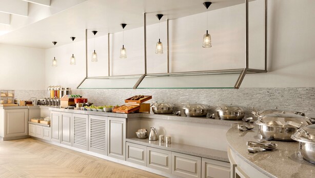 A modern kitchen with a central island, stainless steel appliances, and pendant lighting.