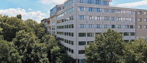 Un edificio de hotel de varios pisos con un diseño arquitectónico moderno, que presenta un techo plano y una señalización llamativa en la parte superior.