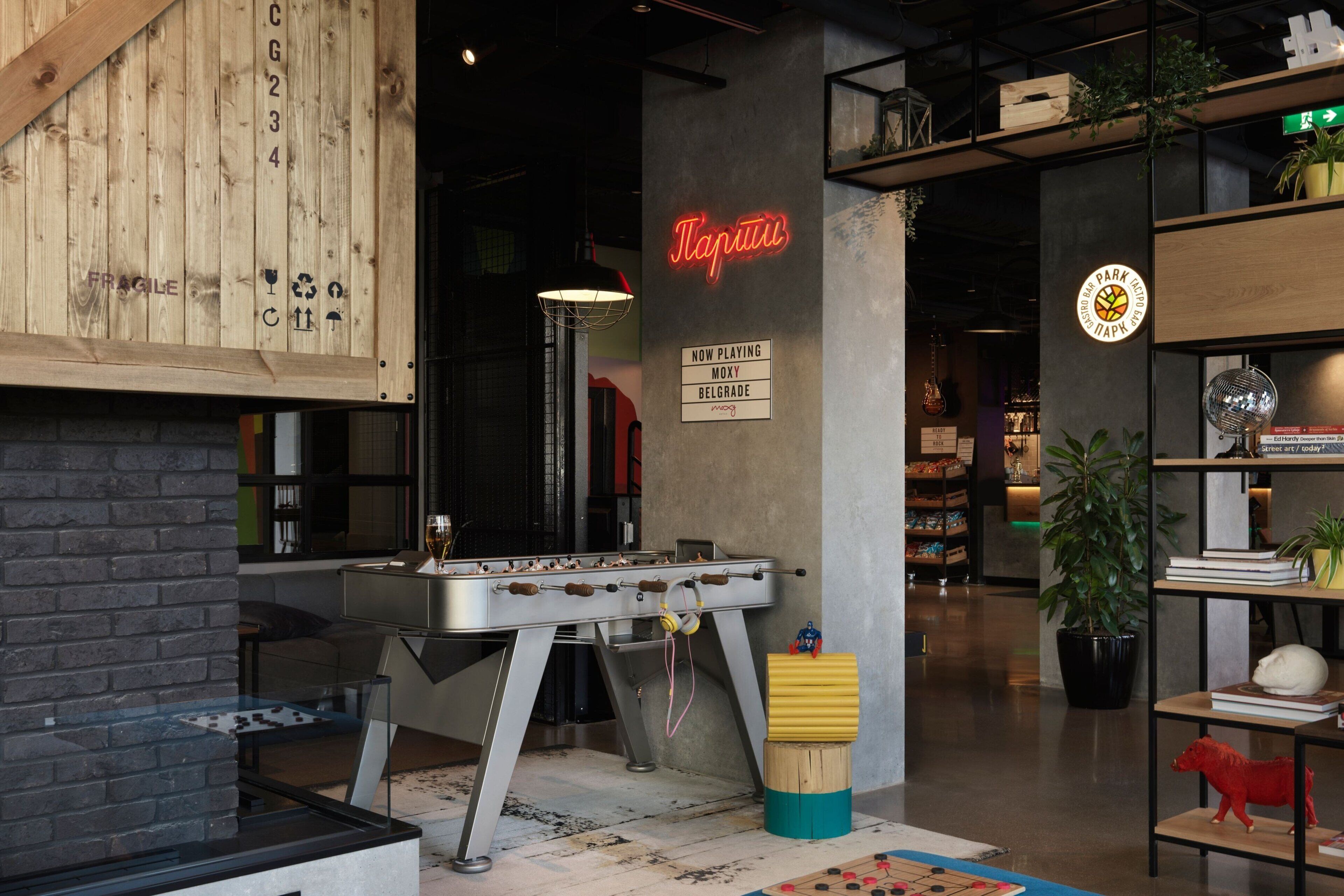 A cozy indoor space with a foosball table, a neon sign, and a sign indicating a live band playing.