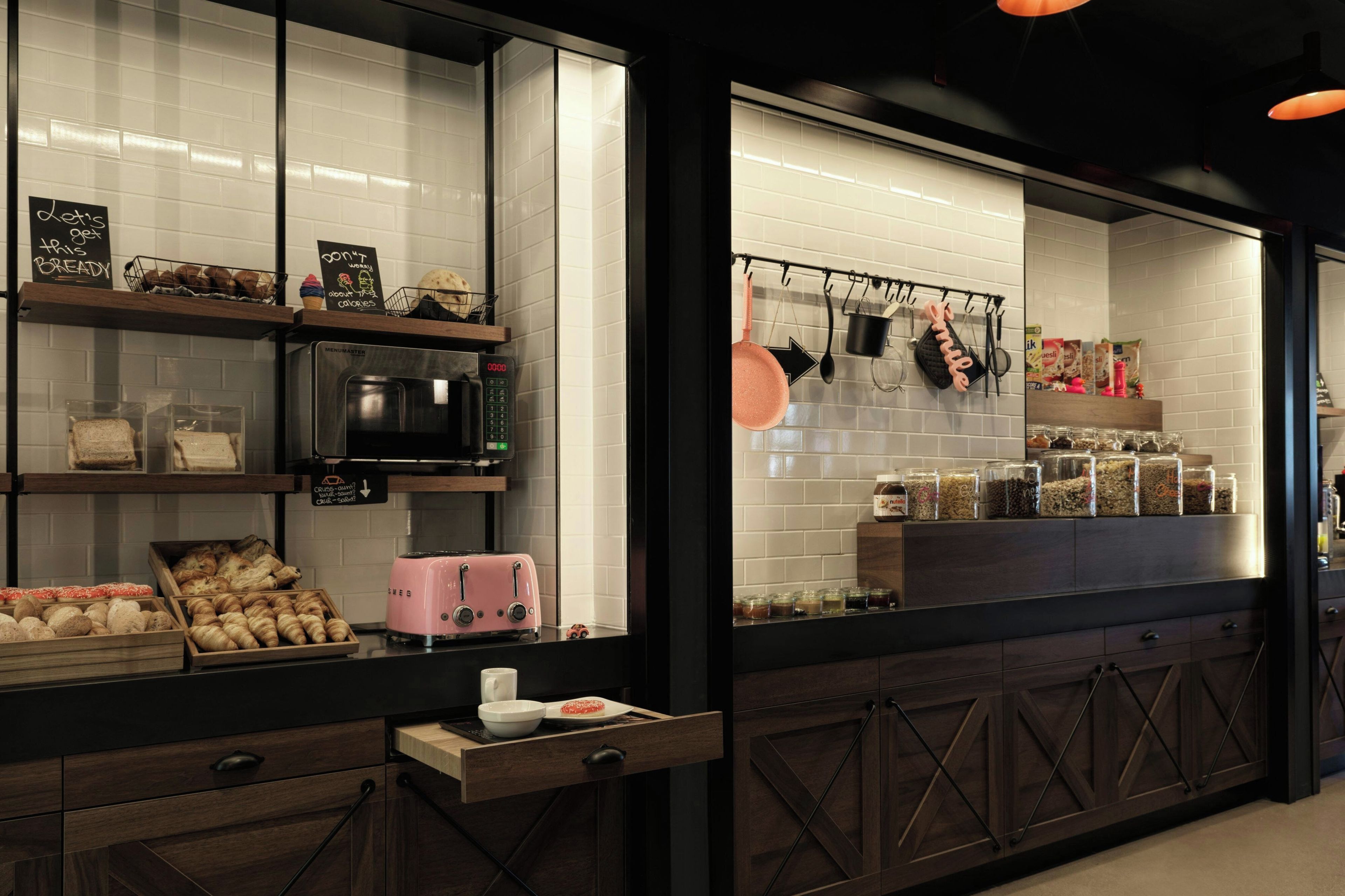 A bakery counter with a microwave, toaster, and various baked goods.