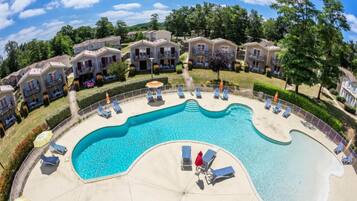 Relax by the resort's central pool surrounded by lounge chairs and umbrellas.