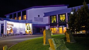 Ein modernes Hotelgebäude mit einer großen Schautafel für Macdonald Hotels & Resorts.