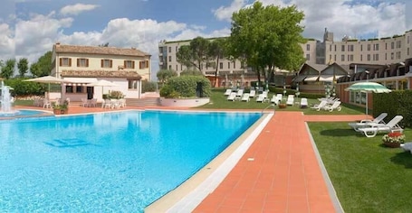 Una piscina al aire libre, sillones reclinables de piscina