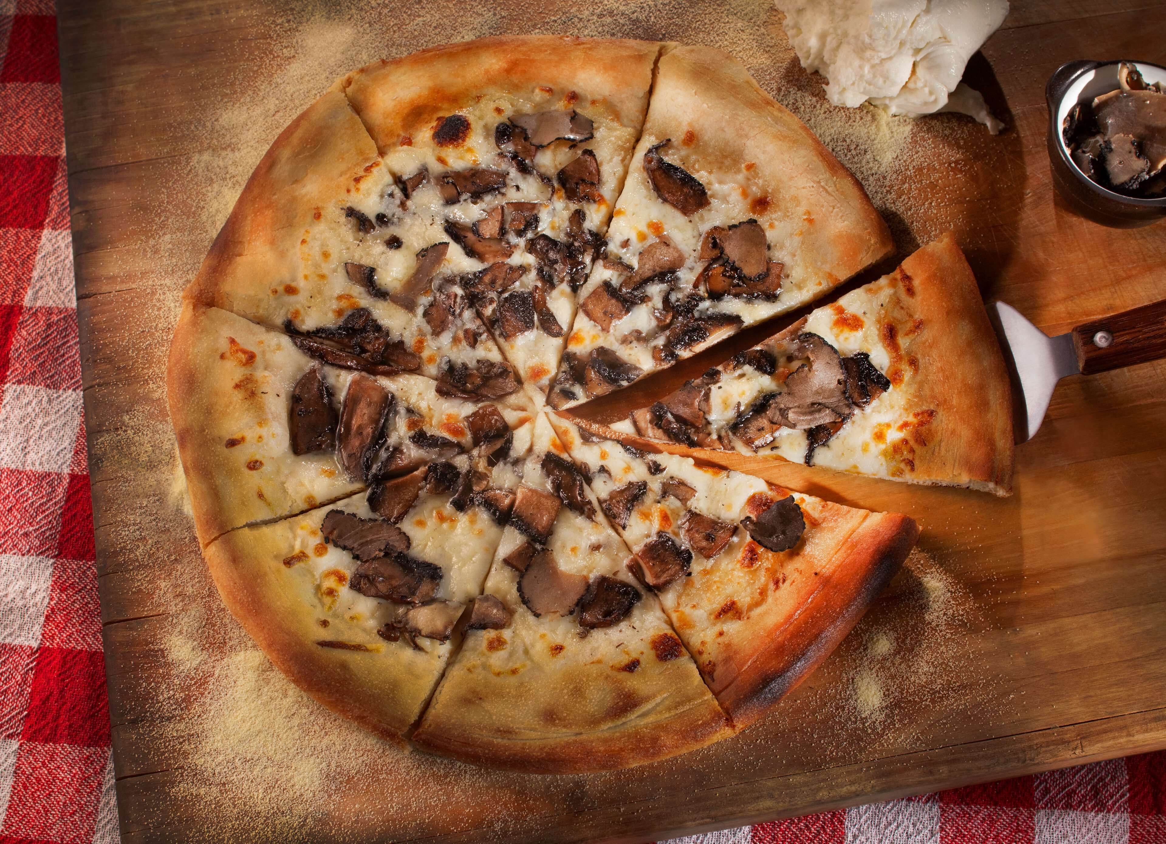 Une pizza à la croûte croustillante, garnie de champignons et de fromage, servie sur une planche en bois.