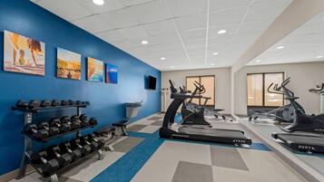 Een sportschool met loopbanden, elliptische trainers en gewichten.
