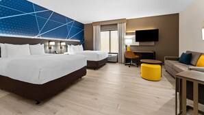 A hotel room with two beds, a desk, a sofa, a TV, and a large window. - Comfort Suites Augusta Riverwatch (Augusta)