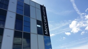 A modern building with a reflective glass facade and a sign reading "Mercure Hotel". - Hôtel Mercure Nantes Ouest Saint-Herblain Zenith (Saint-Herblain)