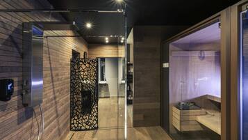 A modern bathroom with a wooden wall, a glass partition, and a shower area.