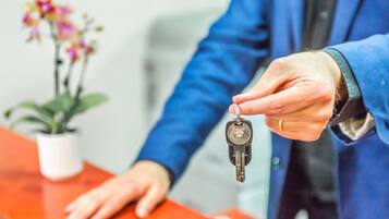 Une personne remet un trousseau de clés à un(e) réceptionniste.