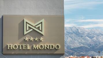 Naamplaat voor Hotel Mondo, met een berg op de achtergrond.