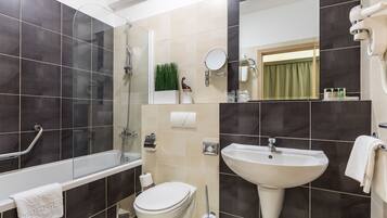 Un baño moderno con bañera, inodoro, lavabo y espejo.