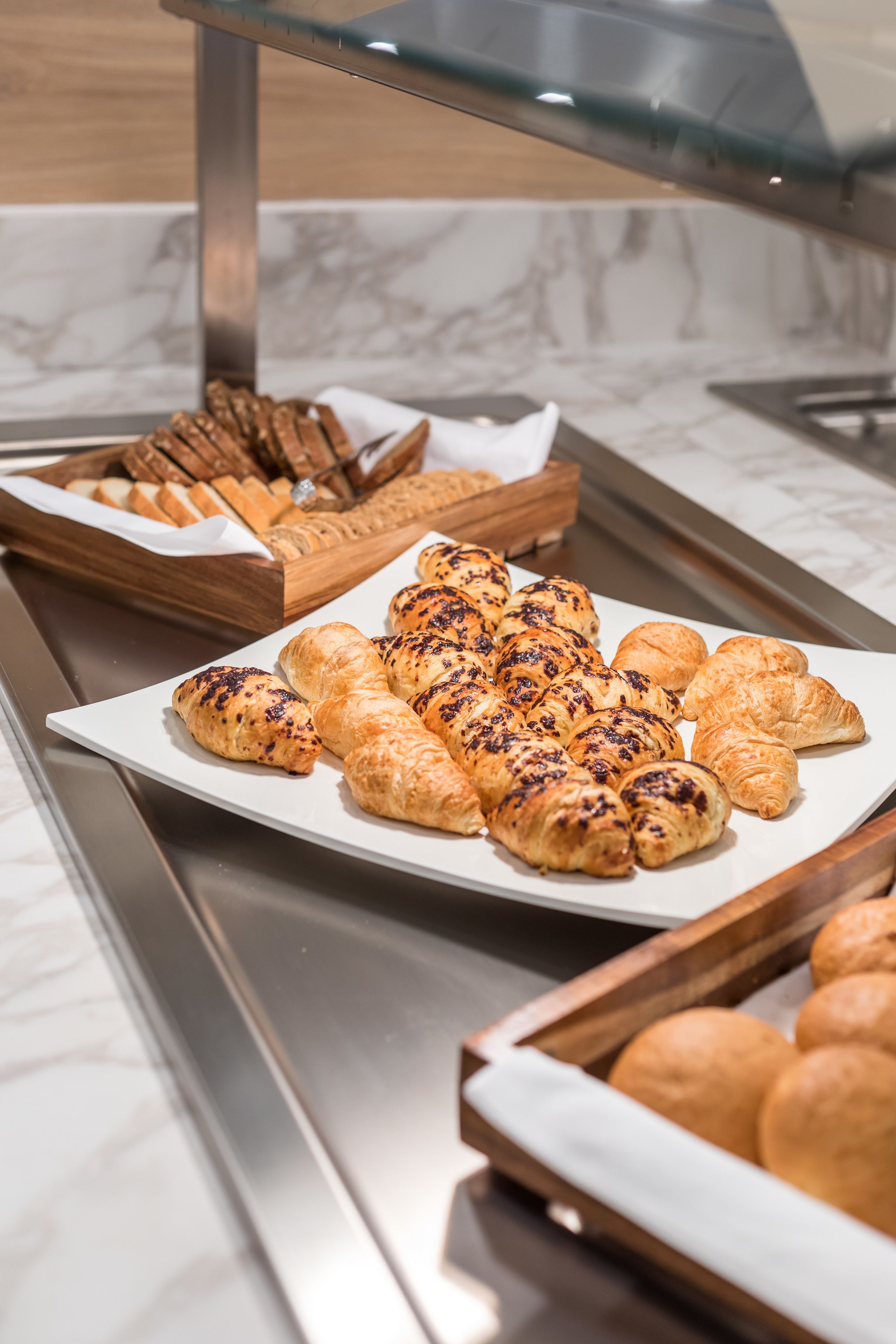 Ein Buffet mit verschiedenen Backwaren, darunter Croissants und Brot.