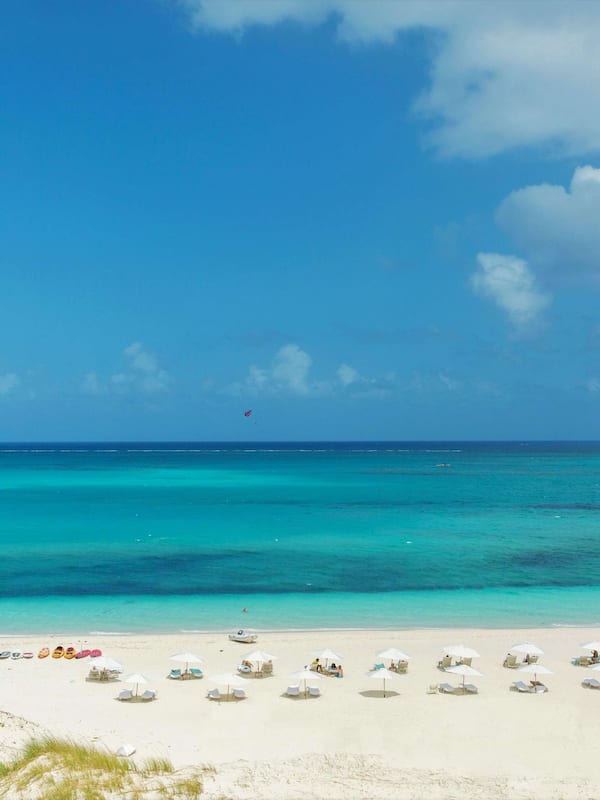 On the beach, white sand, beach cabanas, sun loungers
