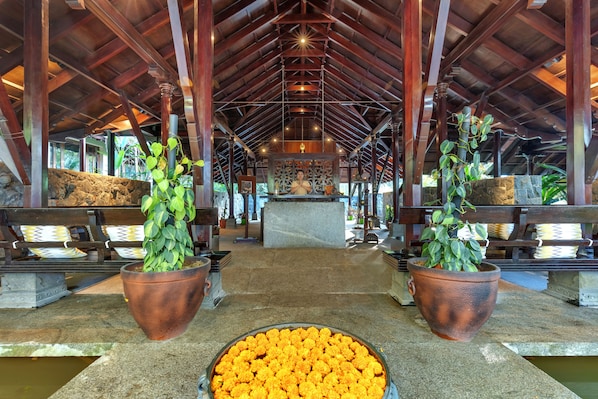 A covered area with a central altar, potted plants, and a stone bench. - Club Mahindra Madikeri, Coorg (Madikeri)