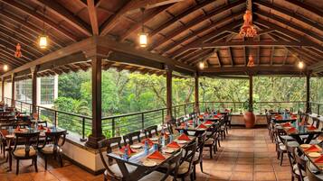 Enjoy meals in a beautifully set dining area with a view of lush greenery.