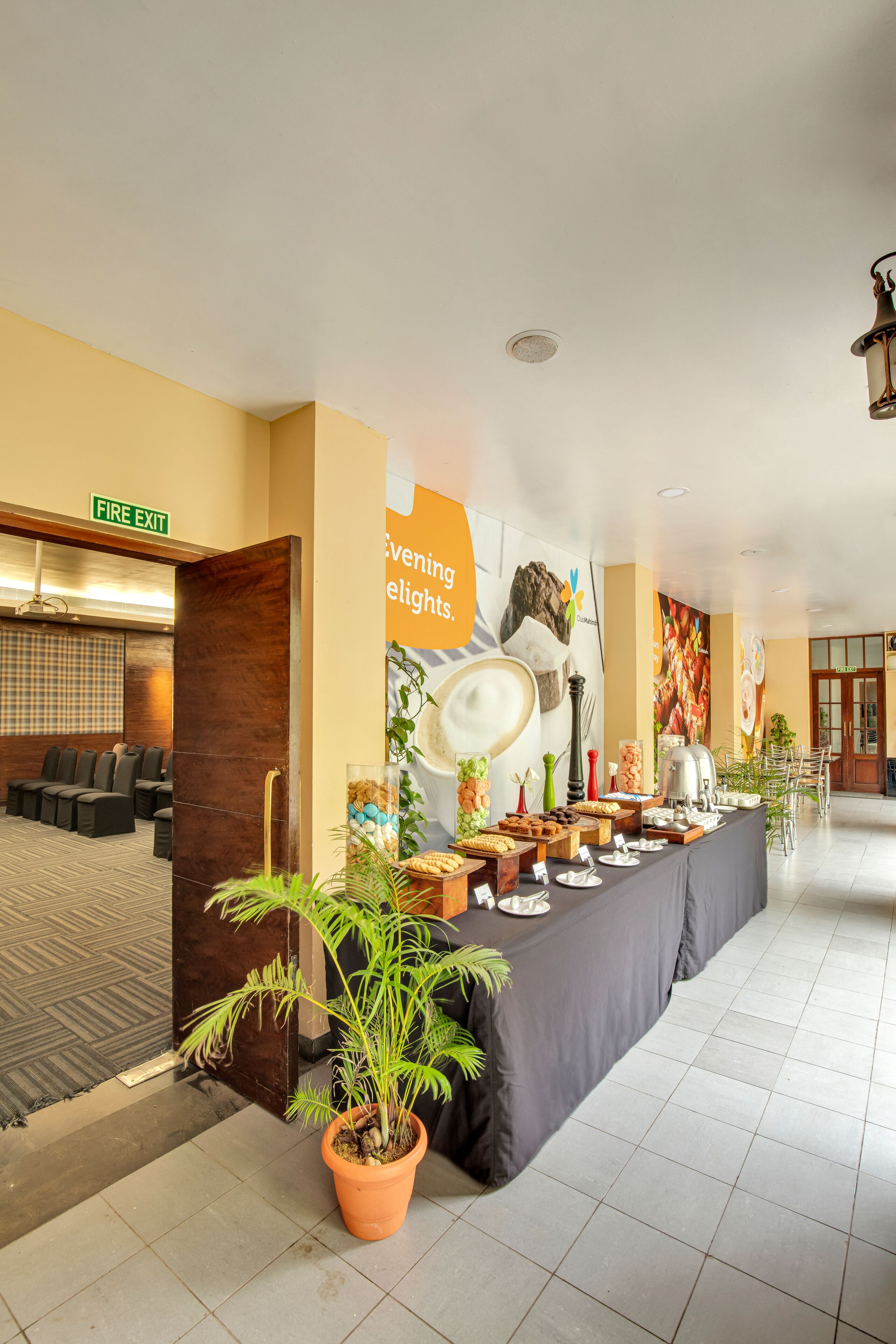 A hotel lobby with a reception desk, seating area, and a buffet table.
