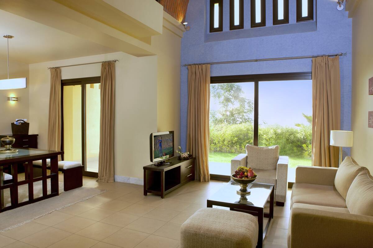 A spacious living room with a TV, sofa, and dining area.