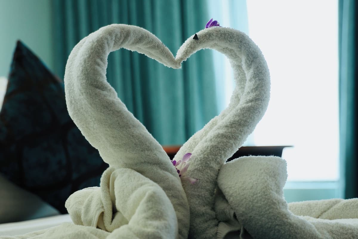 Una cama con una decoración de toallas en forma de cisne.