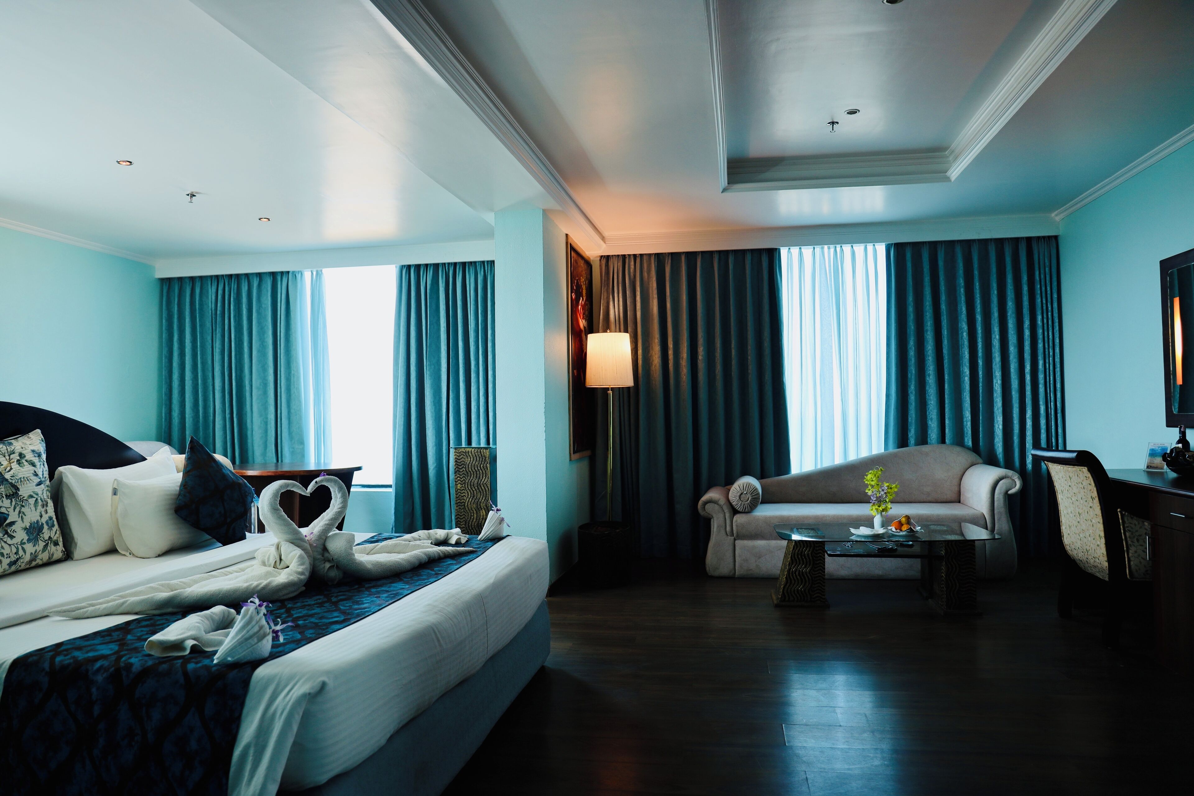 Una habitación de hotel con una cama, un sofá, una mesa de centro y un escritorio.