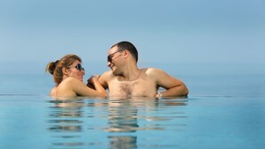 A couple in a clear blue infinity pool with a view of the ocean. - The Quilon Beach Hotel and Convention Center (Kollam)