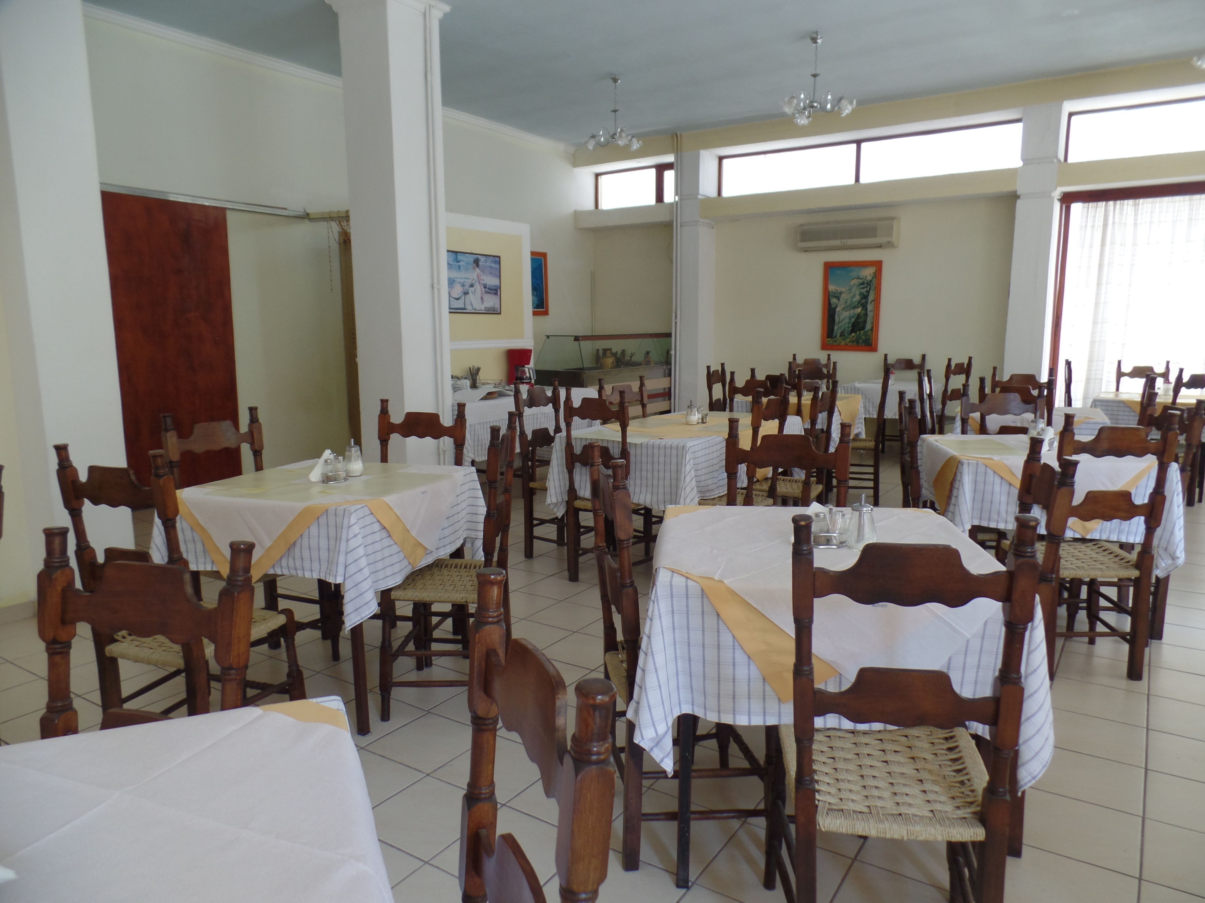 Zona pranzo con diversi tavoli e sedie disposti in file.