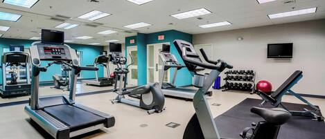 A gym with treadmills, elliptical machines, and weightlifting equipment.