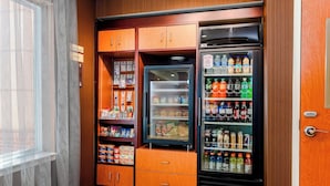 Una kitchenette compacta con refrigerador, congelador y alacenas llenas de provisiones.