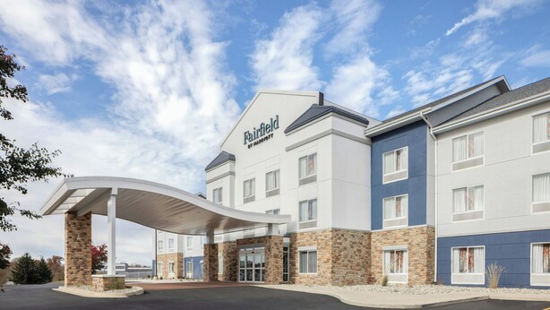Un hotel Fairfield by Marriott con entrada cubierta, fachada de piedra y varias ventanas.