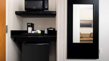 A compact kitchenette with a microwave, coffee maker, and small refrigerator.