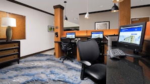 Een hotel receptie met een balie, computer en stoelen.