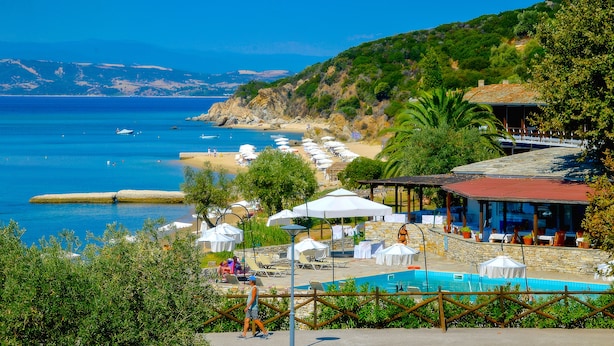 A coastal resort with a swimming pool, beach umbrellas, and a view of the sea. - Xenia (Aristotelis)