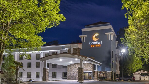 A Comfort Suites hotel with a modern design, featuring a prominent crescent moon logo on the facade. - Comfort Suites At Kennesaw State University (Kennesaw)