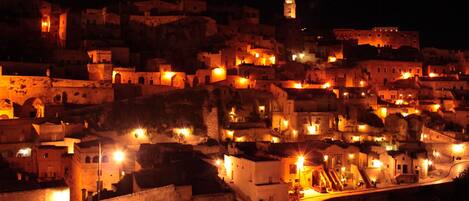 A historic town at night with illuminated buildings and a prominent tower.