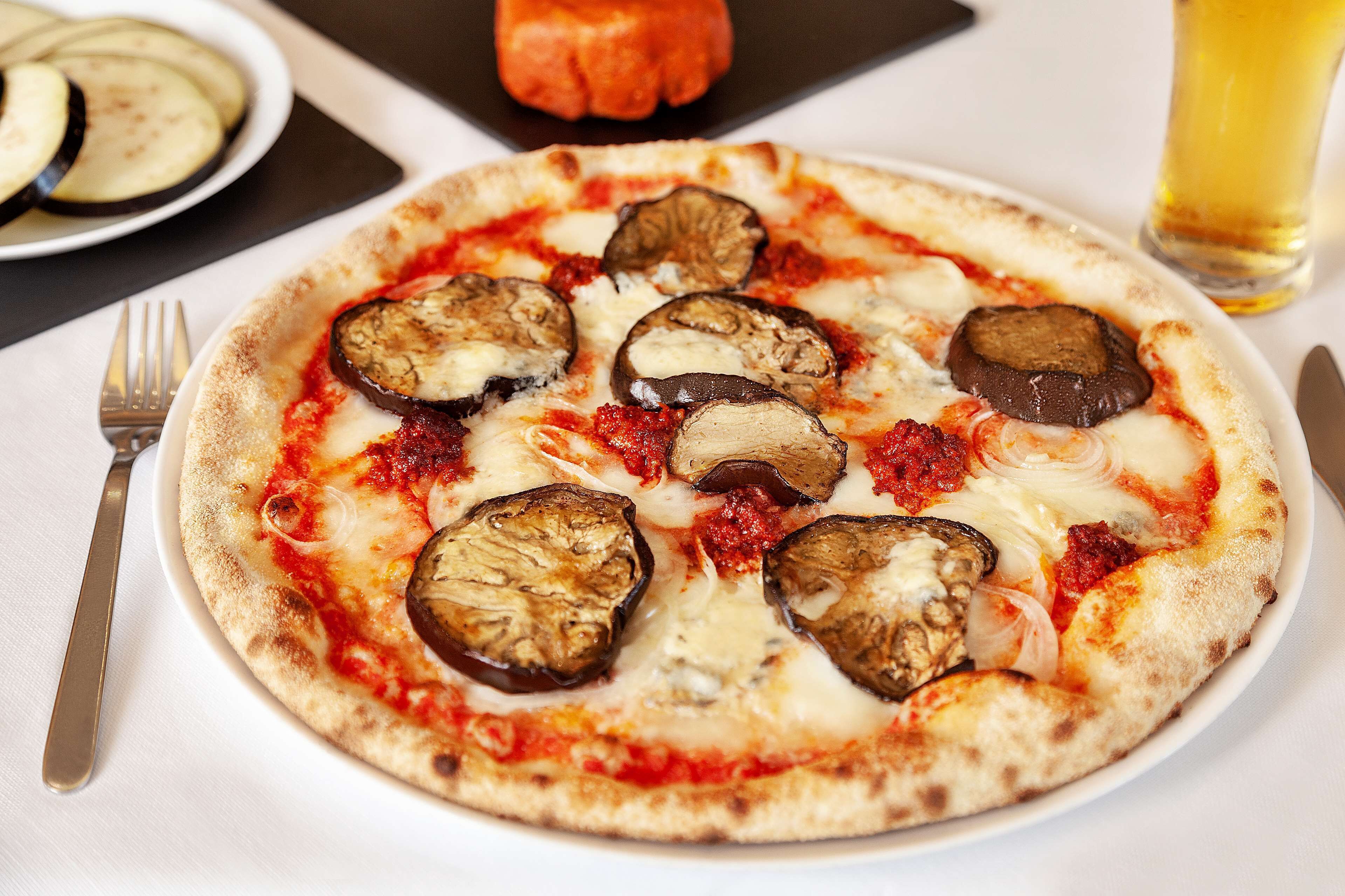 A pizza with various toppings on a white plate.