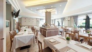 Un restaurant doté de nombreuses tables, d’un bar central et de grandes fenêtres laissant entrer la lumière naturelle.