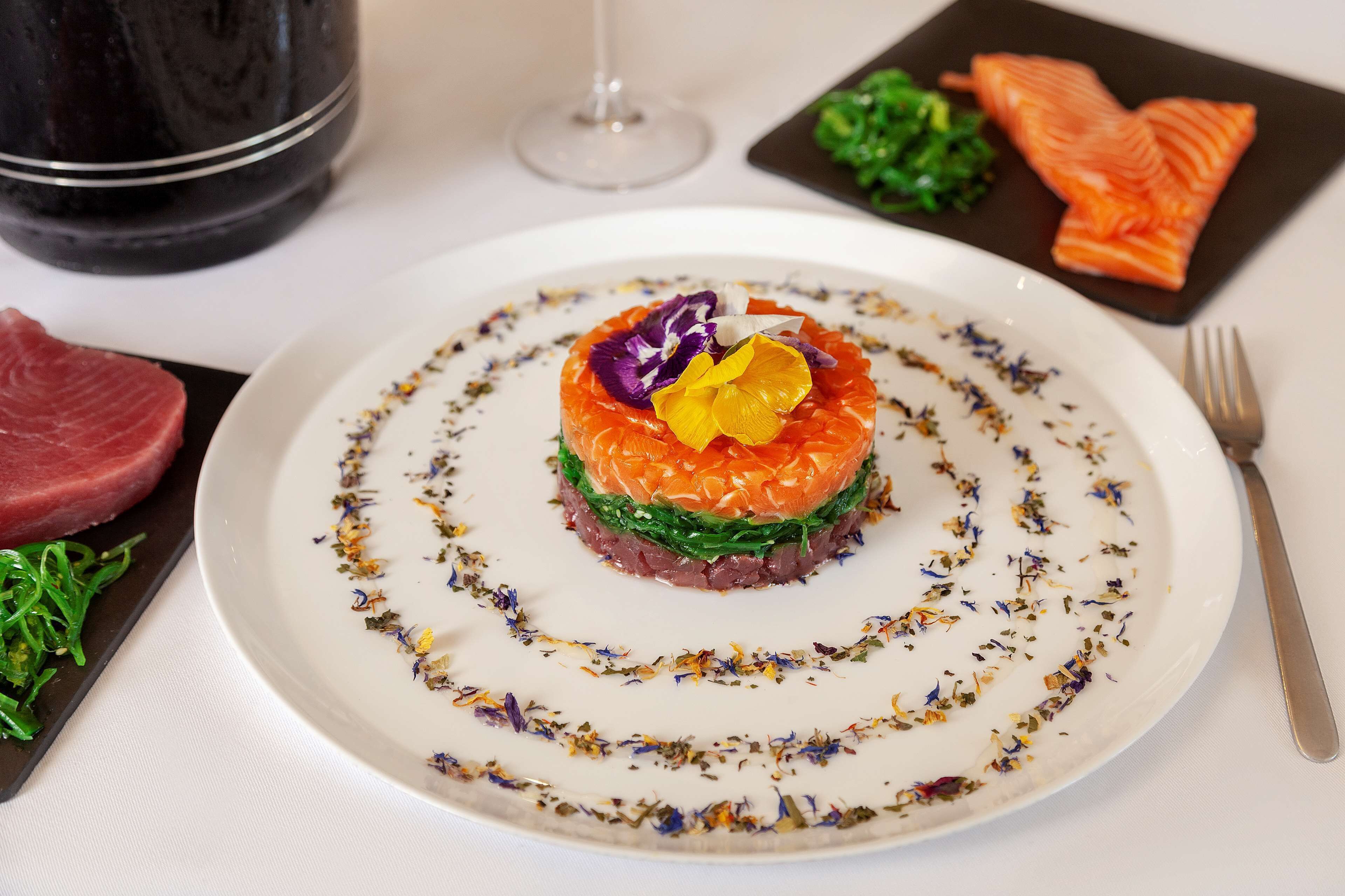 Un plato de comida con una decoración de hierbas y flores.