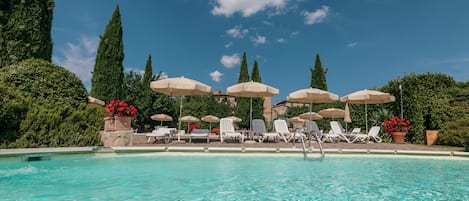 Una piscina techada, una piscina al aire libre de temporada, sombrillas