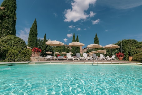 Una piscina techada, una piscina al aire libre de temporada, sombrillas